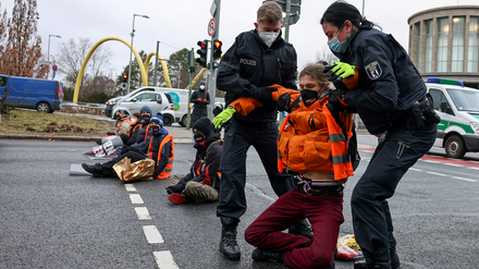 Polizisten tragen einen Blockierer von der Straße. Die Aktivisten wollen ein Essen-Retten-Gesetz.