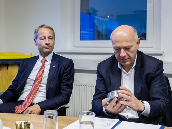 Axel Schweitzer, Eigentümer von Interzero und Berlins Regierender begrüßte am Montag Bürgermeister Kai Wegner (CDU): Wegner inspiziert eine Schatulle voller kleiner Plastikteilchen, die Interzero aus Abfall herstellt.