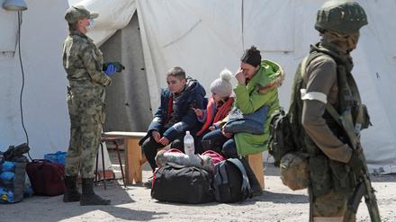 Eine aus dem Stahlwerk Asowstal evakuierte Frau sitzt mit ihren Kindern im Lager Bezimenne.