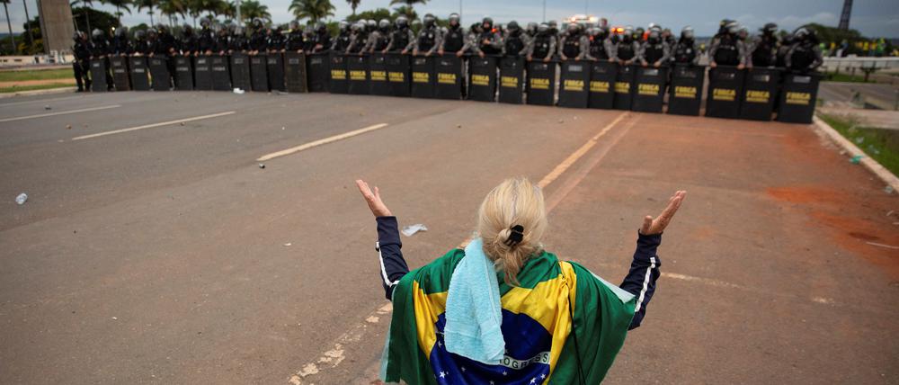 Eine Bolsonaro-Anhängerin vor einer Truppe von Polizisten in Brasilia