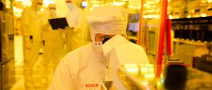 ARCHIV - Ein Mitarbeiter von Bosch kontrolliert am 16.06.2017 in einem Gelbraum eines Wafer fabs (Halbleiterwerk) in Reutlingen (Baden-Württemberg) eine Halbleiterscheibe mit einem Mikroskop auf mögliche Fehler.  (zu dpa «Bosch baut Chipfabrik in Sachsen für eine Milliarde Euro» vom 19.06.2017) Foto: Christoph Schmidt/dpa +++(c) dpa - Bildfunk+++