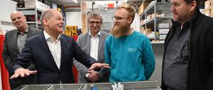 Bundeskanzler Olaf Scholz (SPD) unterhält sich in der Werkstatt der Firma ST Gebäudetechnik mit Techniker Lucas Hohendorf und Projektleiter Meikel Hofbauer (r). Der Bundeskanzler besuchte den Betrieb in seinem Wahlkreis.