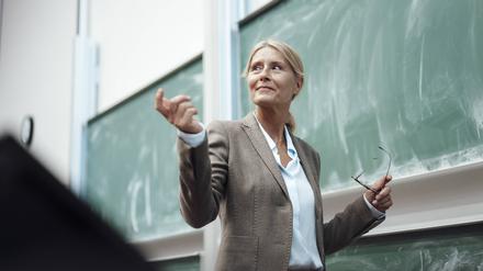 Eine Professorin steht im Hörsaal vor einer Tafel (Symbolbild).