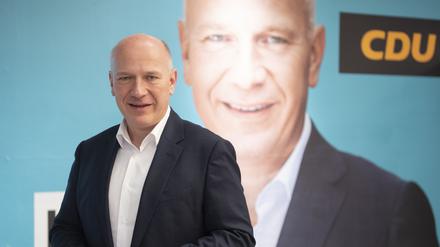 Kai Wegner, Spitzenkandidat und Landesvorsitzender der CDU Berlin, posiert vor einem Pressetermin vor einem Wahlplakat seiner Partei.