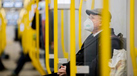 Ein Mann sitzt mit FFP2-Maske in der U-Bahn.  Foto: dpa/Christoph Soeder