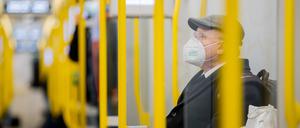 Ein Mann sitzt mit FFP2-Maske in der U-Bahn.  Foto: dpa/Christoph Soeder