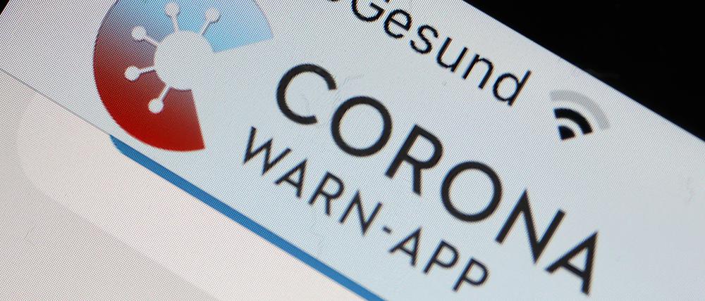 Die Corona-Warn-App mit der Seite zur Risiko-Ermittlung ist im Display eines Smartphone zu sehen.