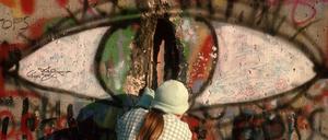 Eine Frau meisselt ein Stück Stein als Andenken aus der Berliner Mauer. Berlin, 09.11.1989.