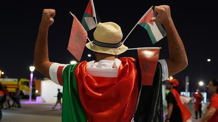 Gesamtansicht: Ein Fan posiert mit Palästina- und Marokko -Flaggen vor dem Stadion.