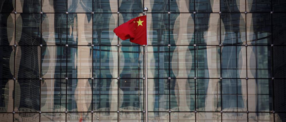 Chinas Nationalflagge vor einer Bank in Peking