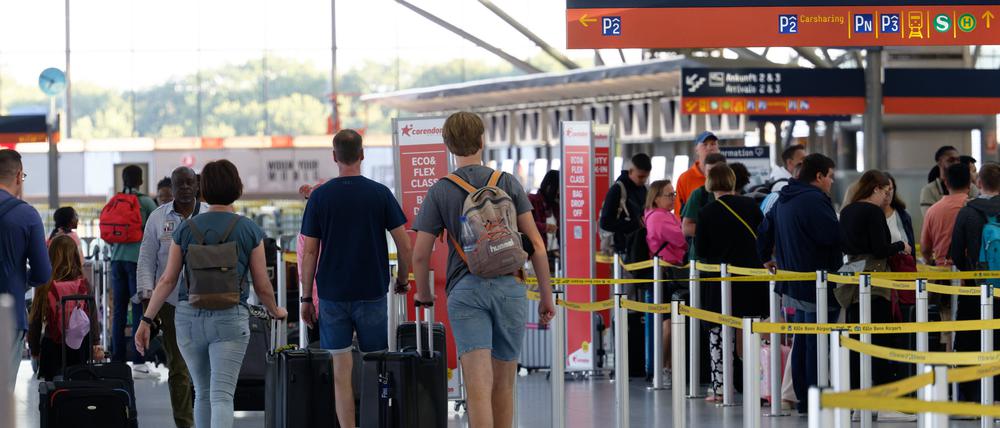 Reisende gehen im Flughafen Köln/Bonn durch die Abflughalle: Flüge ins Ausland sind deutlich teurer geworden. Auch Pauschalreisen kosten etwa 10 Prozent mehr im Vergleich zum letzten Jahr. 