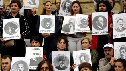 Türkische und armenische Bürger halten Bilder von getöteten armenischen Völkermordopfern.
