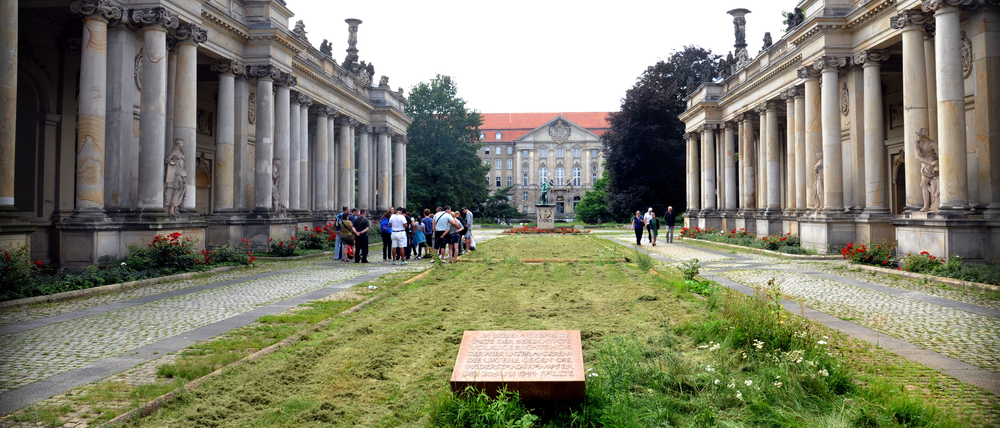 Blick durch die Kolonnaden in den Kleistpark, vorn die Gedenktafel für die Opfer des nationalsozialistischen „Volksgerichtshofs“, der auch im Kammergericht tagte, das hinten zu sehen ist.