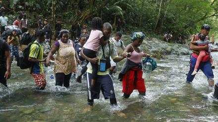 Familien mit ihren Habseligkeiten auf dem Fußmarsch durch den Darién-Dschungel.