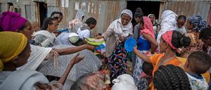 Vertriebene aus der Region Tigray in Äthiopien stehen in Mekele Schlange, um von Anwohnern gespendete Lebensmittel zu erhalten. 