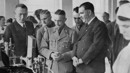 Alfred Meyer, NSDAP-Gauleiter (Mitte, in Uniform), besucht 1937 ein Oetker-Werk.