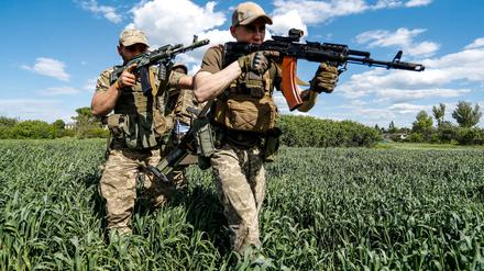 Ukrainische Soldaten marschieren durch Gelände im Donbass.