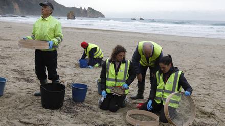 Freiwillige säubern den Strand in Muros de Nalon, Spanien.