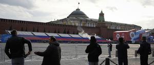 Menschen schauen auf den leeren Roten Platz, der für die Vorbereitung der Siegesparade neben dem Moskauer Kreml gesperrt ist.