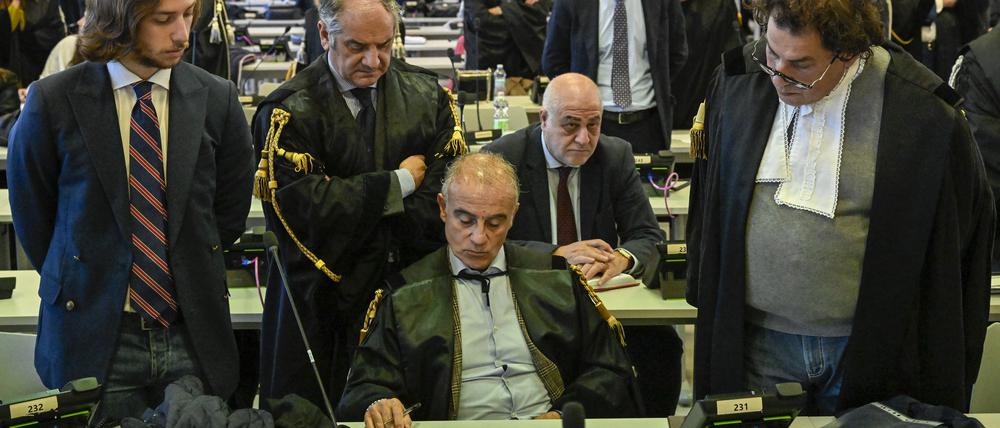 Beamte hören zu, wie Richterin Cavasino die Urteile des Prozesses verliest. In Italiens größtem Mafia-Prozess seit Jahrzehnten ist ein ehemaliger Abgeordneter der Regierungspartei Forza Italia zu elf Jahren Haft verurteilt worden. 