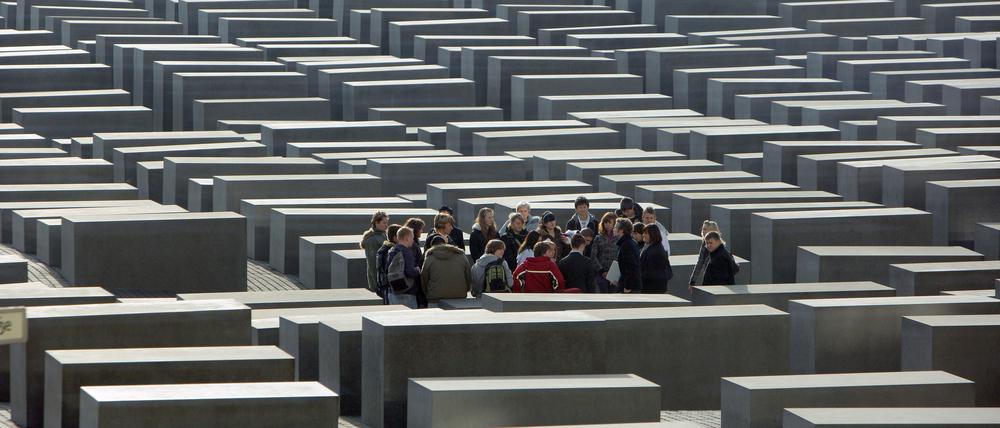 Eine Schulklasse steht inmitten des Stelenfeldes des Holocaust-Mahnmals in Berlin.