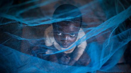 Ein Kind aus Burundi unter einem Moskitonetz