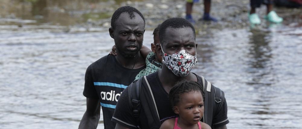Migranten aus Haiti überqueren den Fluss Tuquesa nach einer Reise zu Fuß durch den Dschungel in der Provinz Darién.