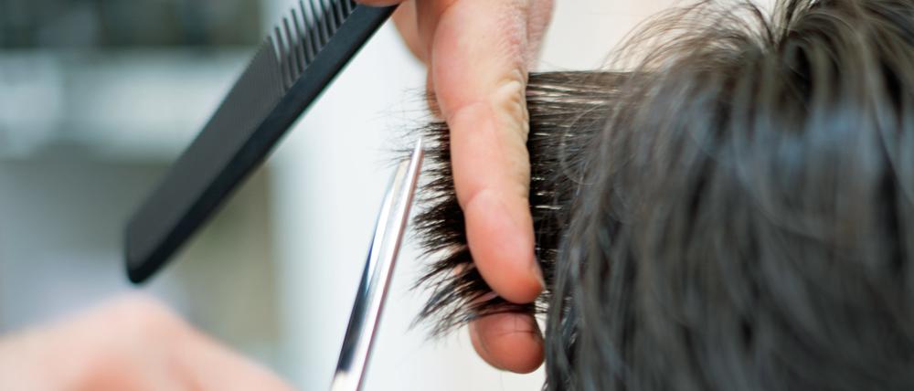 ARCHIV - 29.04.2021, Berlin: Ein Friseur schneidet in einem Friseur-Salon einer Kundin mit einer Schere die Haare. Von der Erhöhung des Mindestlohns in Deutschland am 1. Oktober profitieren nach einer neuen Studie rechnerisch 6,64 Millionen Menschen in Deutschland. (zu dpa «Studie: 6,64 Millionen profitieren von höherem Mindestlohn») Foto: Symbolbild Friseur/dpa +++ dpa-Bildfunk +++