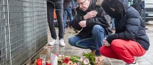 Ein Mann bekreuzigt sich am Gebäude der Zeugen Jehovas an der Deelböge im Hamburger Stadtteil Alsterdorf, nachdem Blumen und Kerzen niedergelegt wurden. 