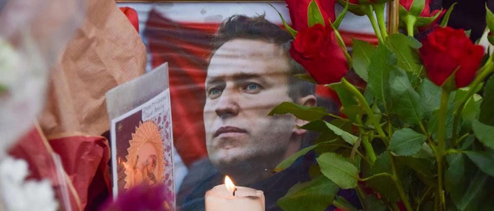 An einer behelfsmäßigen Gedenkstätte gegenüber der russischen Botschaft stehen Blumen, Kerzen, und Karten.