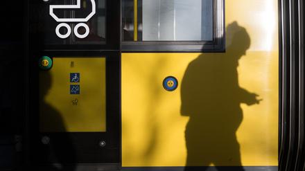 Ein Mann geht an einer Tram der BVG entlang. 