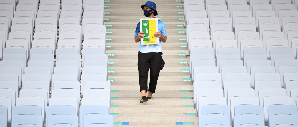 Neuer olympischer Dreikampf: Ein Volunteer erinnert im fast leeren Stadion von Miyagi an das Maskentragen, Händewaschen und Abstandhalten.  Foto: Molly Darlington/Reuters