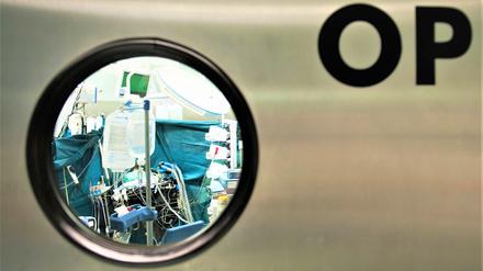 Blick durch ein Fenster in einen Operationssaal.