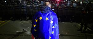 Mit einer EU-Flagge hat sich ein Demonstrant in Tiflis eingehüllt, der gegen das umstrittene Gesetz auf die Straße gegangen ist. 