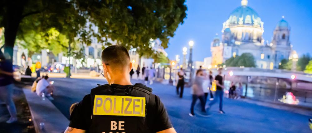 Ein Polizist weist Besucher im James-Simon-Park im Berliner Bezirk Mitte auf das Alkoholverbot hin. (Symbolbild)