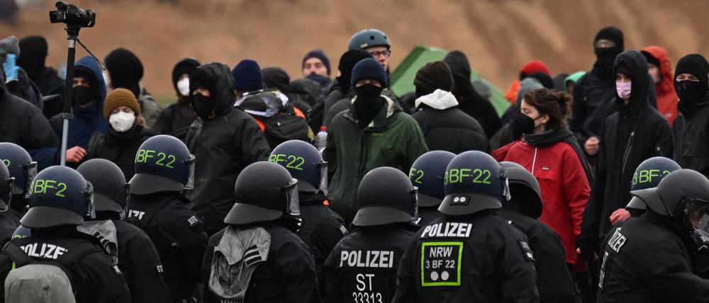 Polizisten stehen Aktivisten in Lützerath gegenüber.