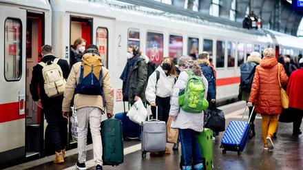  Zahlreiche Reisende steigen an Heiligabend 2021 am Bahnhof in einen IC der Deutschen Bahn (DB) ein.