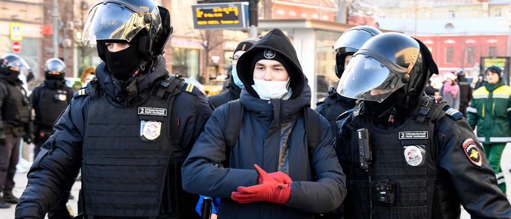 Police officers detain a man during a protest against Russia's invasion of Ukraine in central Moscow on February 27, 2022. (Photo by Alexander NEMENOV / AFP)