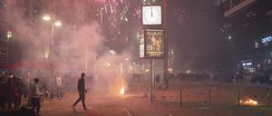 Menschen feiern Silvester mit Feuerwerk auf dem Alexanderplatz.