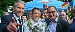 Björn Höcke  (l) , Vorsitzender der AfD Thüringen und Tino Chrupalla, AfD-Bundesvorsitzender (r) gratulieren dem Wahlsieger des Thüringer Kreis Sonneberg, Robert Sesselmann (AfD, M) im Garten eines Restaurant.