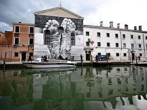Ein Paar nackte Füße, schmutzig und verwundet, sind auf die Fassade der Kapelle des Frauengefängnisses in Venedig gemalt. Ein Werk des italienischen Künstlers Maurizio Cattelan.