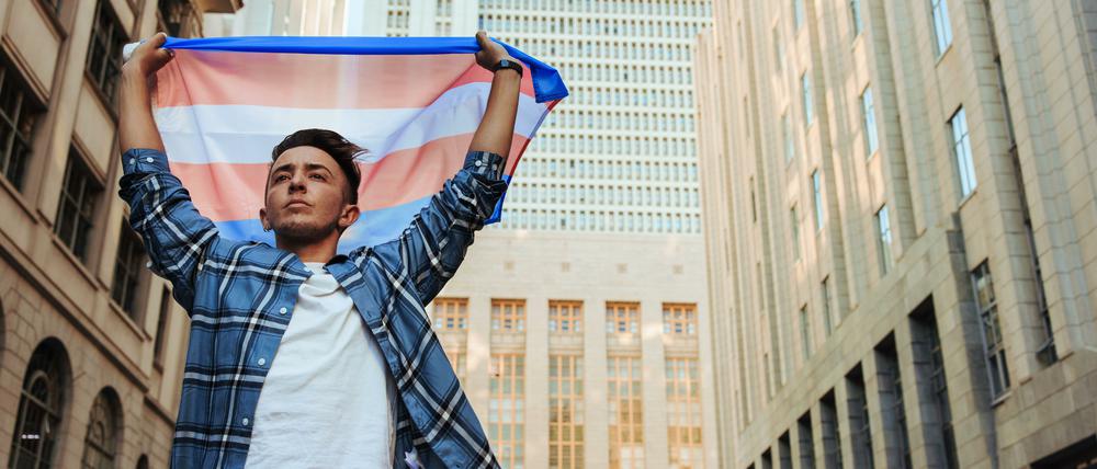 Ein trans Mann zeigt die trans Flagge in New York.