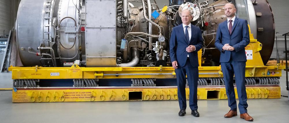 Bundeskanzler Olaf Scholz (SPD) steht mit Christian Bruch (r), Vorstandsvorsitzender von Siemens Energy, an der in Kanada für die Erdgas-Pipeline Nordstream 1 gewarteten Turbine. 