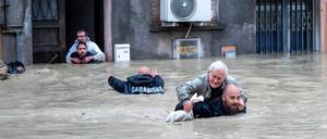 Carabinieri tragen Anwohner huckepack durch die überschwemmten Straßen. Die italienischen Regionen Emilia-Romagna und die Marken werden weiter von schweren Unwettern heimgesucht.