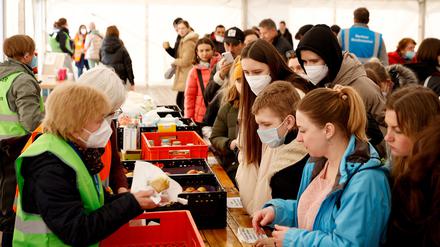 Helfer verteilen Lebensmittel an Kriegsflüchtlinge aus der Ukraine in der „Welcome Hall Land Berlin“, der ersten Anlaufstelle nach der Ankunft der Flüchtlinge auf dem Hauptbahnhof.