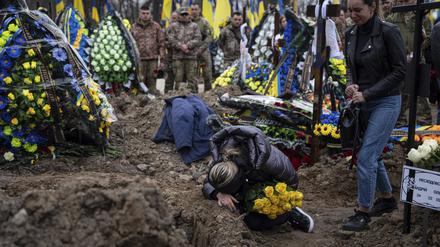 Eine Ukrainerin weint in Kiew am Grab ihres gefallenen Mannes.