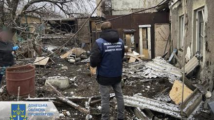 Ukrainischer Staatsanwalt für Kriegsverbrechen bei der Inspektion von Trümmern nach einem Beschuss.