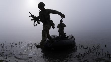 Ukraine, Cherson: Ein ukrainischer Soldat springt am Ufer des Dnipro-Flusses.