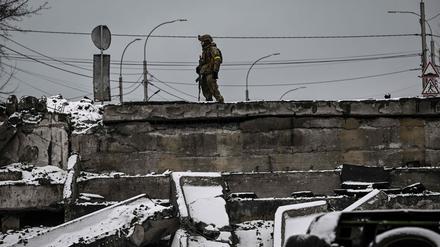 Ein ukrainischer Soldat steht an einer zerstörten Brücke im Norden von Kiew.