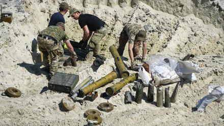 Ukrainische Soldaten bereiten sich darauf vor, nicht explodierte russische Munition zu zünden.